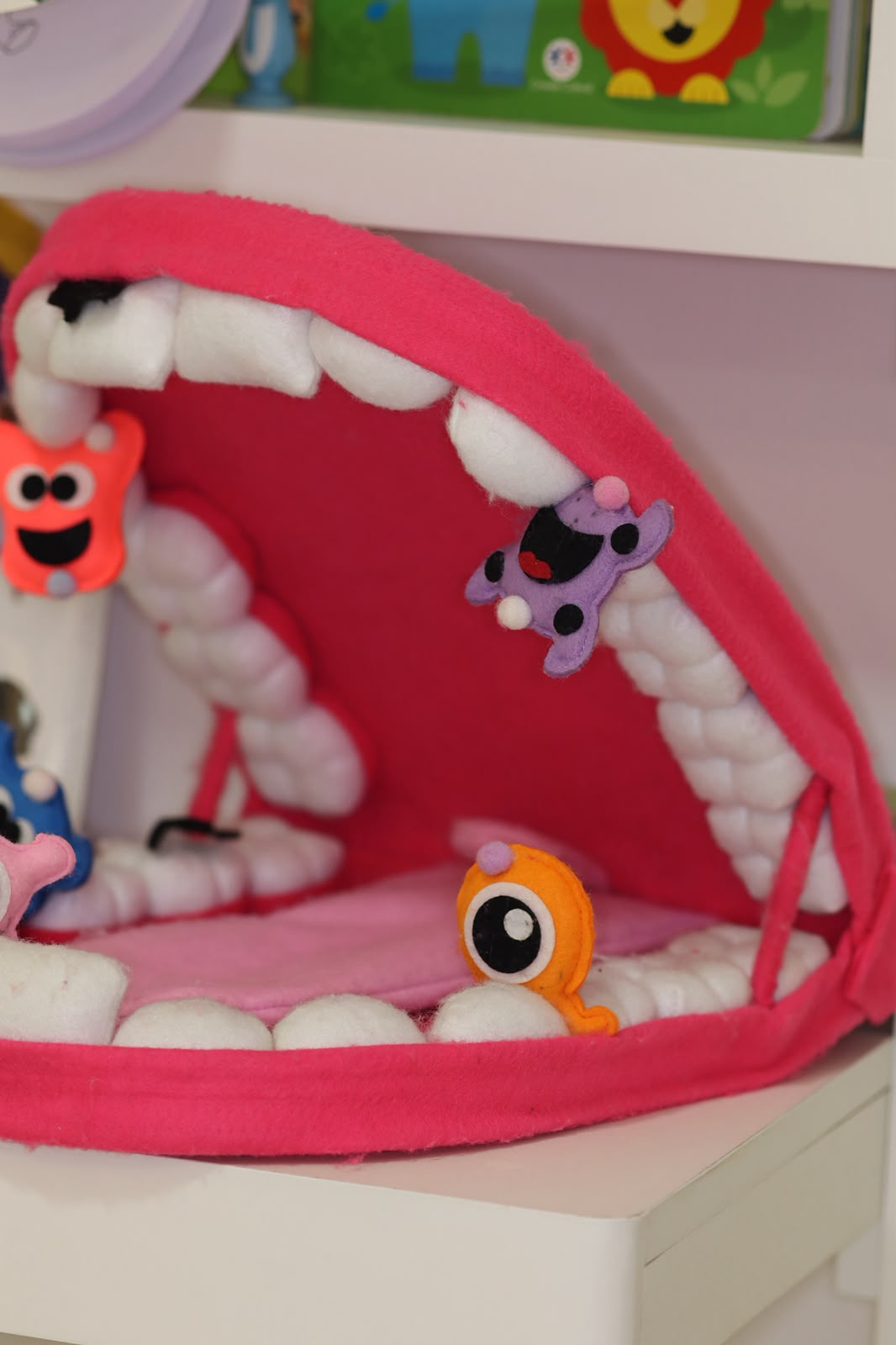 Boca de pelúcia com dentinhos usada para explicar a higiene